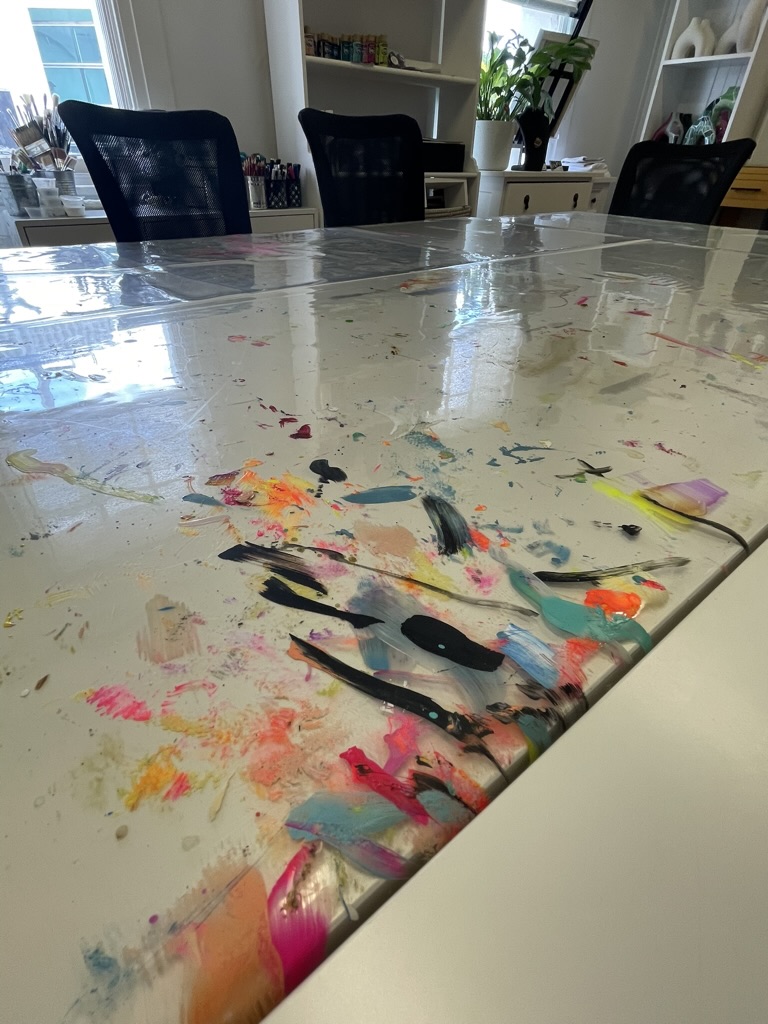 A close-up of the paint-splattered table top — evidence of a real working studio